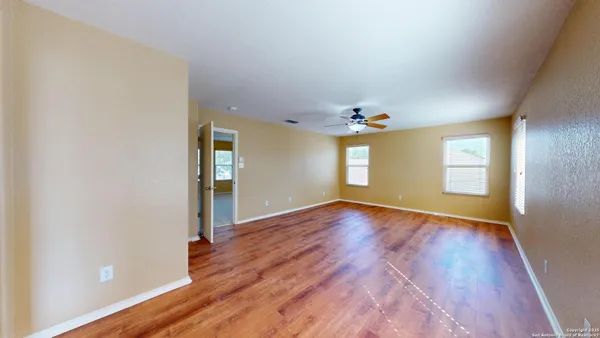 an empty room with wooden floor and natural light