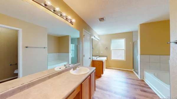 a bathroom with a tub sink and mirror