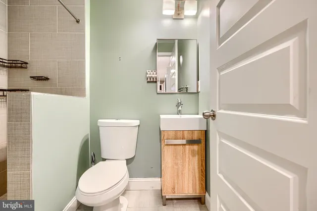 a bathroom with a toilet sink and mirror