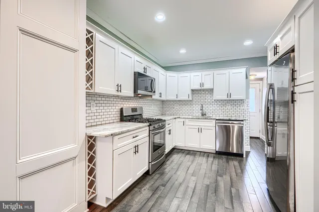a kitchen with stainless steel appliances a refrigerator sink and cabinets