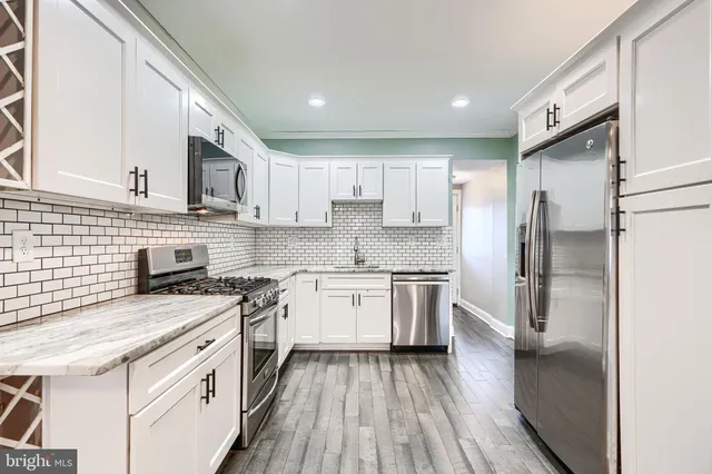 a kitchen with stainless steel appliances granite countertop a stove a sink and a refrigerator