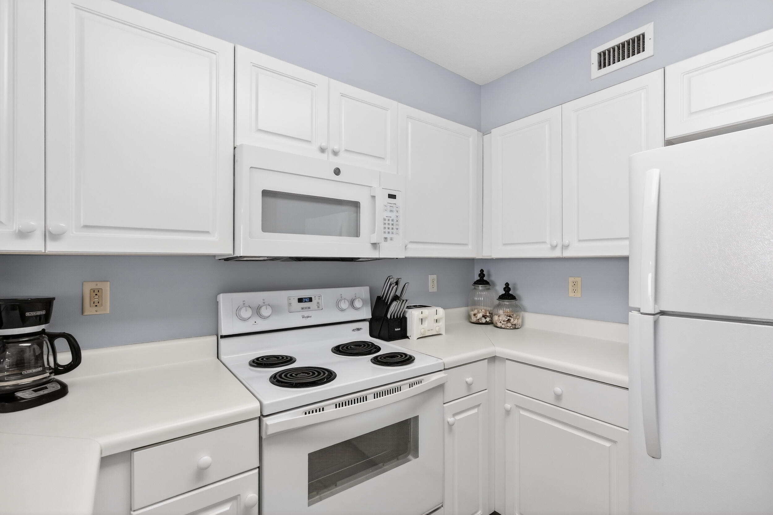 866 Santa Rosa Boulevard, Unit 317 Fort Walton Beach, FL 32548 - Photo 13 of 46 a kitchen with white cabinets and white appliances