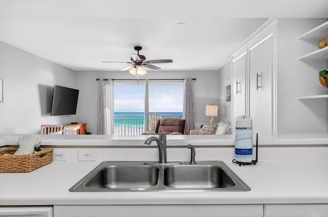 a kitchen view with a sink and a flat screen tv