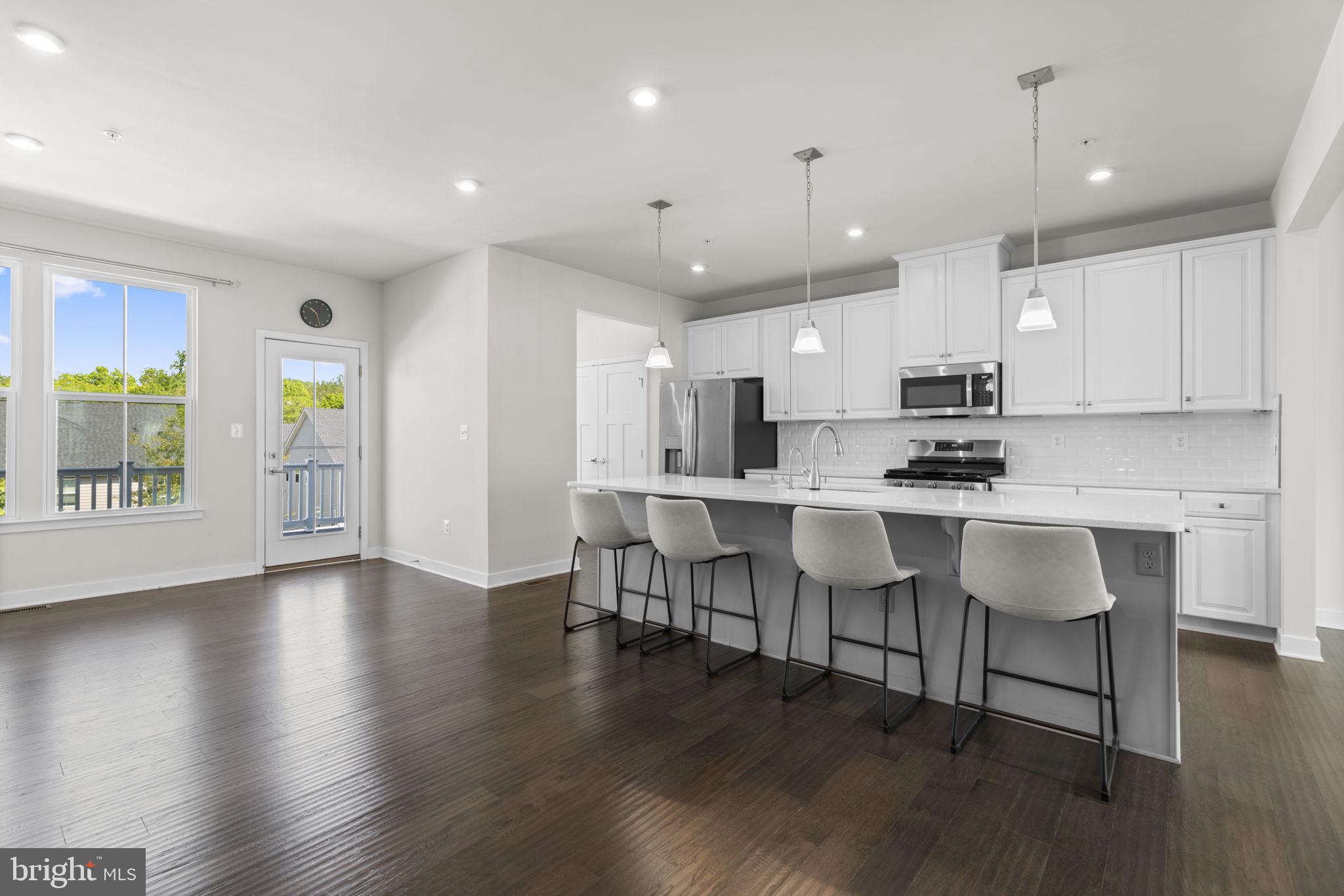 733 Iron Gate Road Bel Air, MD 21014 - Photo 14 of 41 a kitchen with stainless steel appliances kitchen island granite countertop a stove a sink a refrigerator and white cabinets with wooden floor
