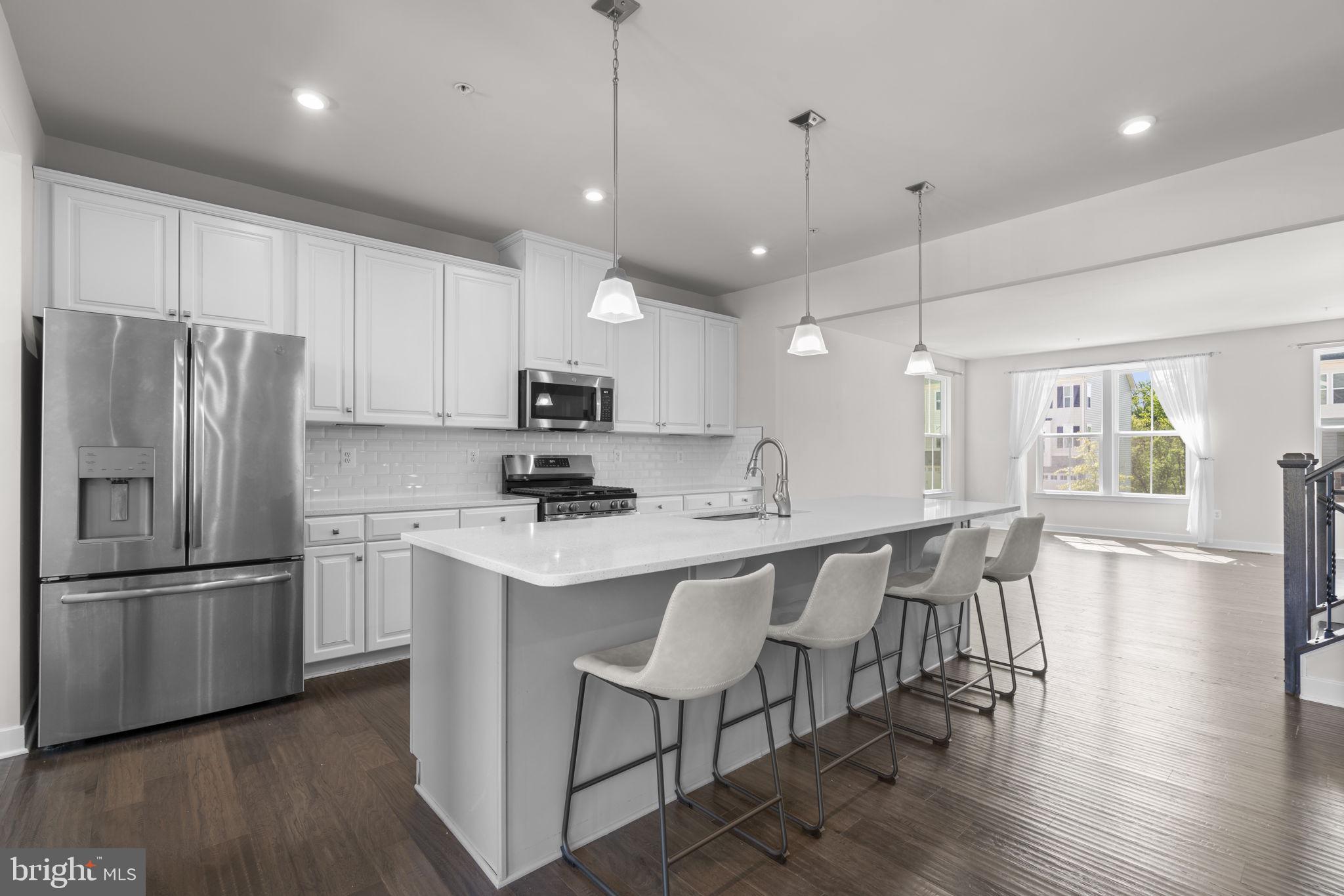 733 Iron Gate Road Bel Air, MD 21014 - Photo 8 of 41 a kitchen with stainless steel appliances granite countertop a table chairs refrigerator and microwave