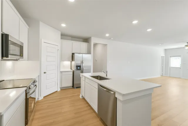a kitchen with a sink a refrigerator and cabinets