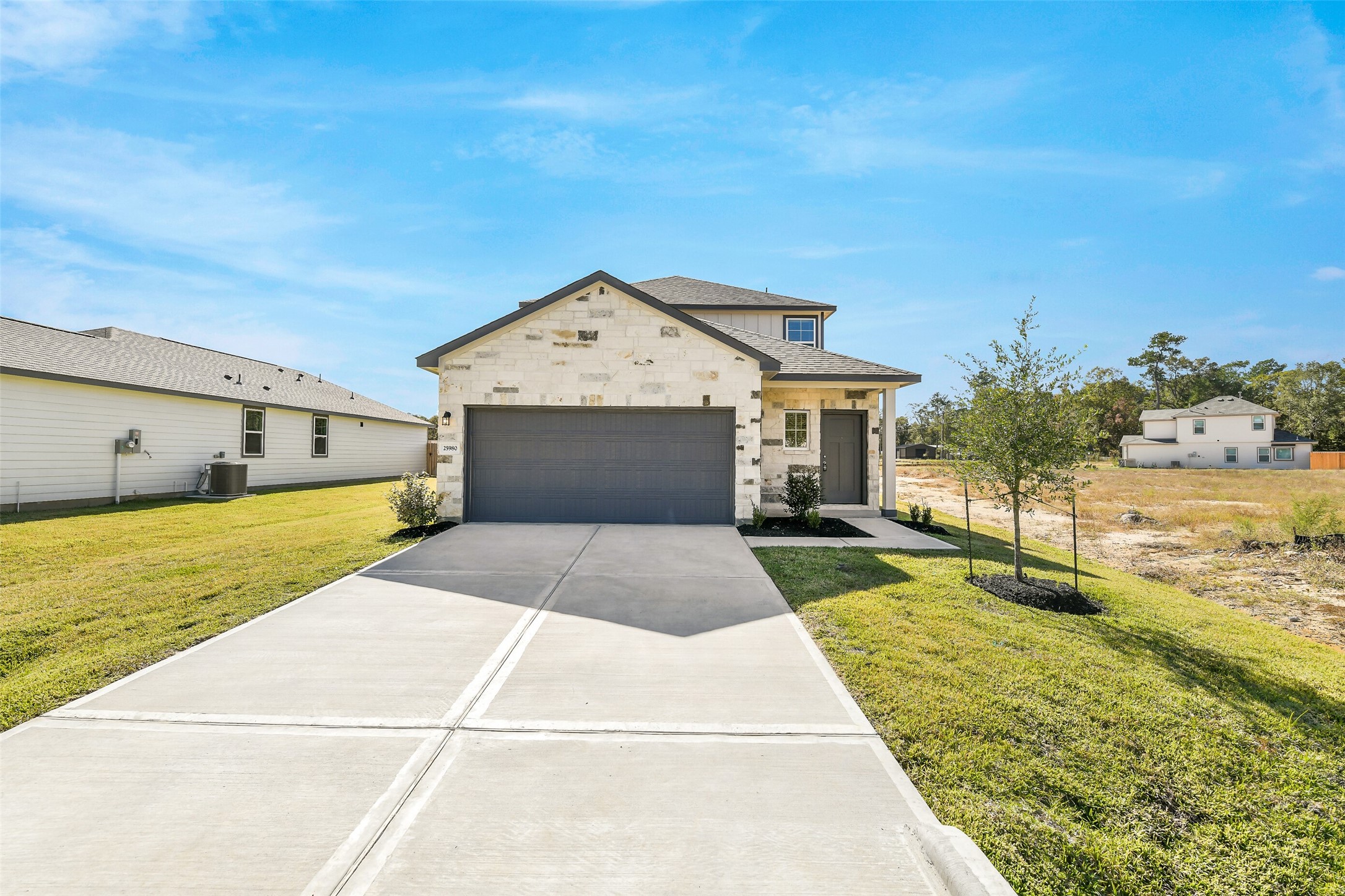 25980 Liberation Road Cleveland, TX 77328 - Photo 3 of 42 a front view of a house with a yard and garage