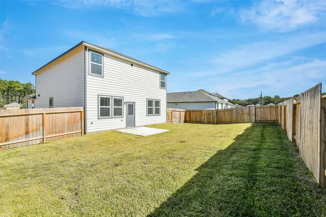 a view of an house with backyard and a tree