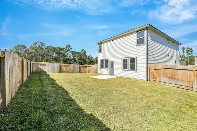 a view of an house with backyard and road