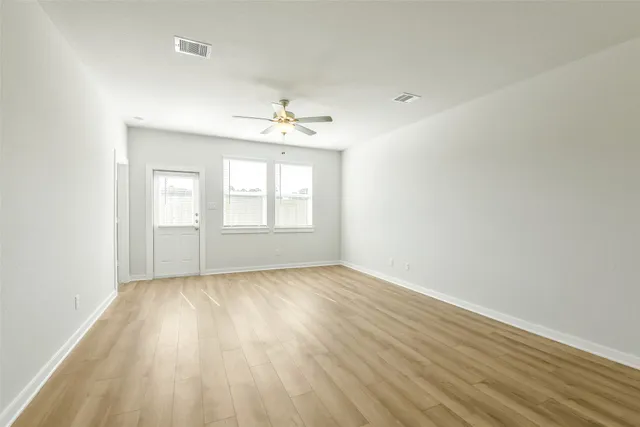 wooden floor in an empty room with a window