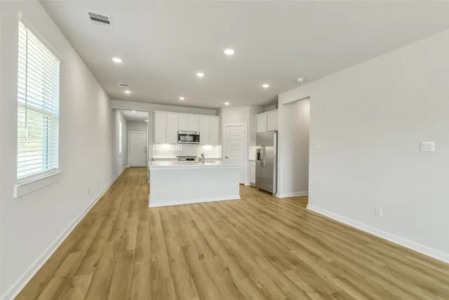 a view of kitchen with wooden floor and electronic appliances