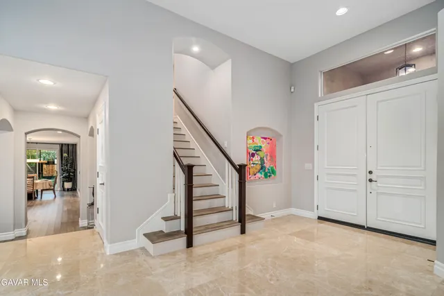 a kitchen with stainless steel appliances a dining table chairs and wooden floor