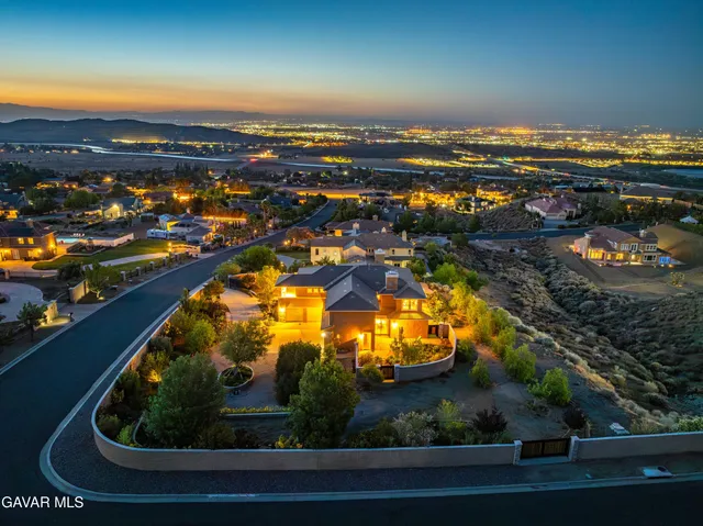 a view of a house with many windows and flower plants