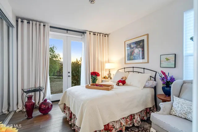 an empty room with wooden floor chandelier fan and windows