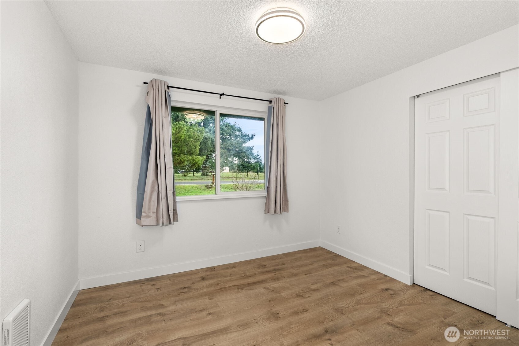18821 Guava Street Southwest Rochester, WA 98579 - Photo 14 of 28 an empty room with wooden floor and windows