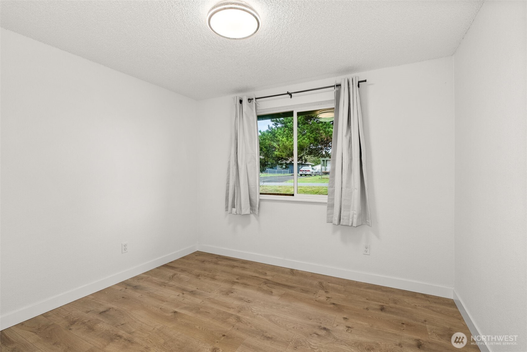 18821 Guava Street Southwest Rochester, WA 98579 - Photo 15 of 28 a view of an empty room with wooden floor and a window