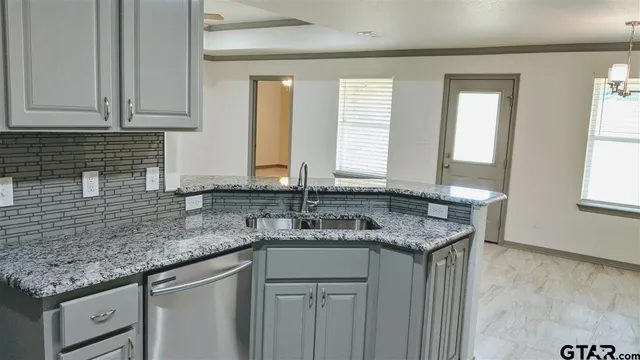 a kitchen with stainless steel appliances granite countertop a sink a window and a counter space