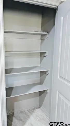 a view of walk in closet with empty racks