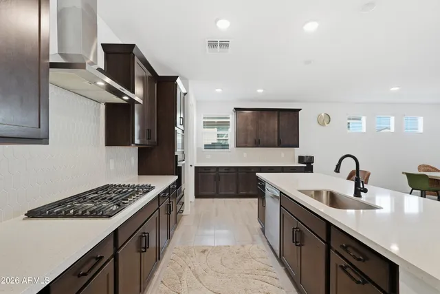 a view of an empty room with a window and a kitchen