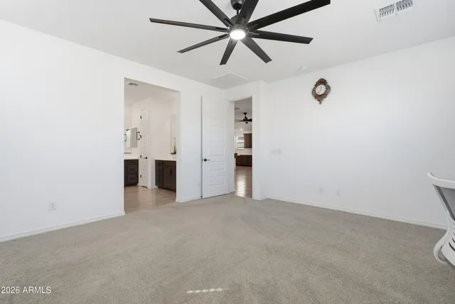 an empty room with a window and a ceiling fan
