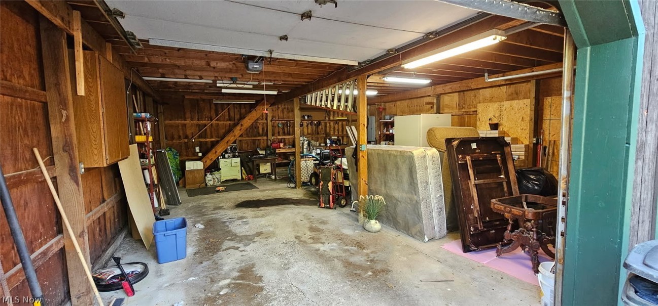 12590 Rockhaven Road Chesterland, OH 44026 - Photo 20 of 25 Two-car garage with exposed wood beam ceiling, concrete flooring, and fluorescent lighting