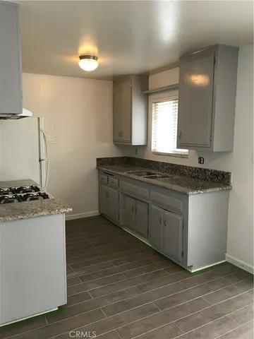 a kitchen with granite countertop a stove and a sink
