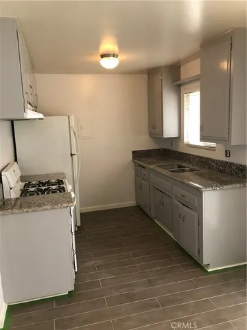 a kitchen with granite countertop a stove and a sink