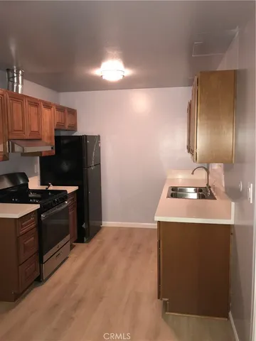 a kitchen with granite countertop a sink stove and refrigerator