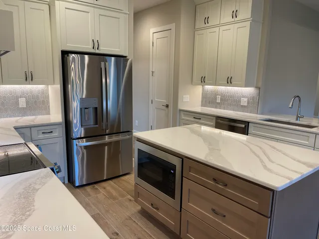a kitchen with granite countertop a refrigerator stove and sink