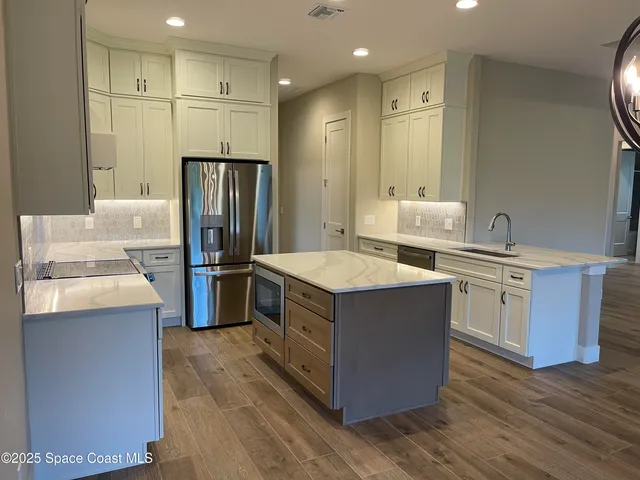 a kitchen with stainless steel appliances a stove a refrigerator and a oven