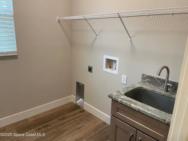 a view of a sink and dishwasher with wooden floor
