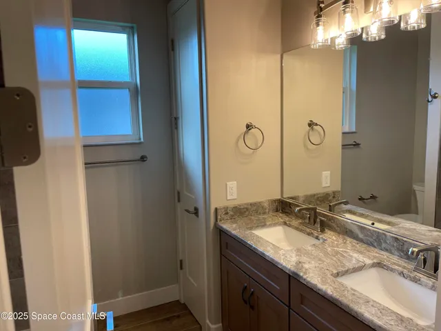 a bathroom with a granite countertop sink and a mirror
