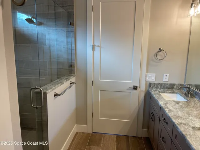 a bathroom with a granite countertop shower sink and mirror
