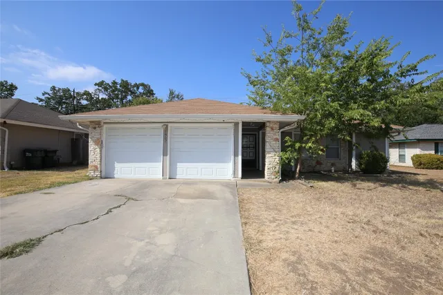 front view of a house with a yard and a garage