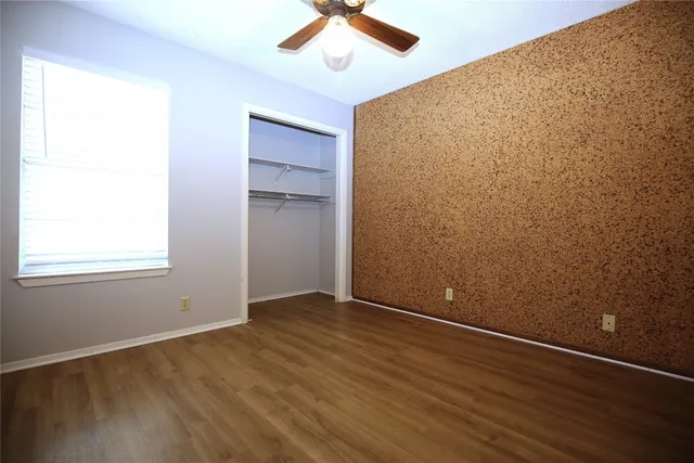 an empty room with a ceiling fan and carpet