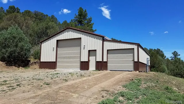 a wooden house with a yard and large tree