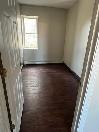 an empty room with wooden floor and a window