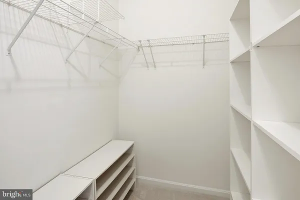 an empty room with windows and ceiling fan