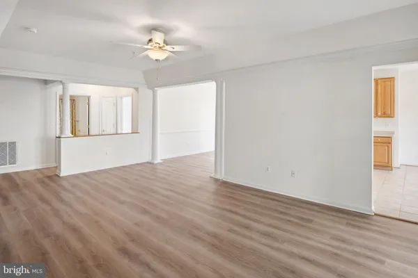 a view of an empty room with a window and wooden floor