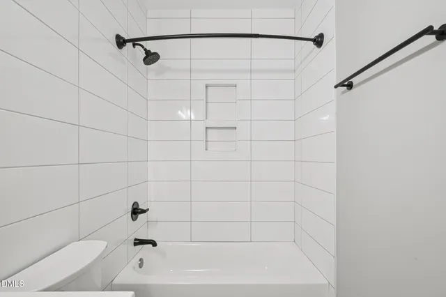 an empty room with a chandelier fan and windows