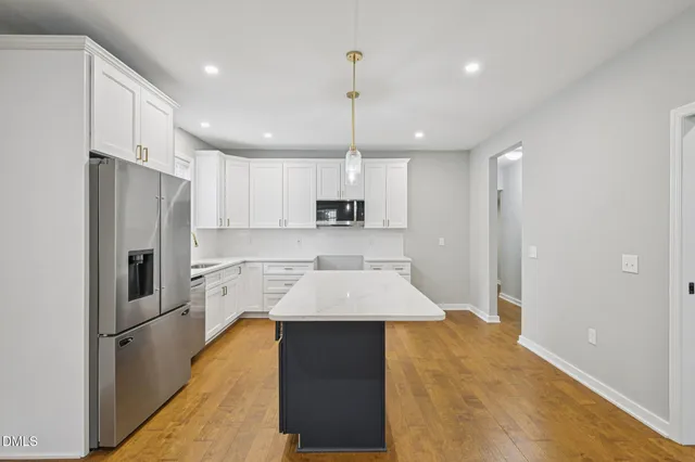 a kitchen with a stove a wooden floor and a ceiling fan