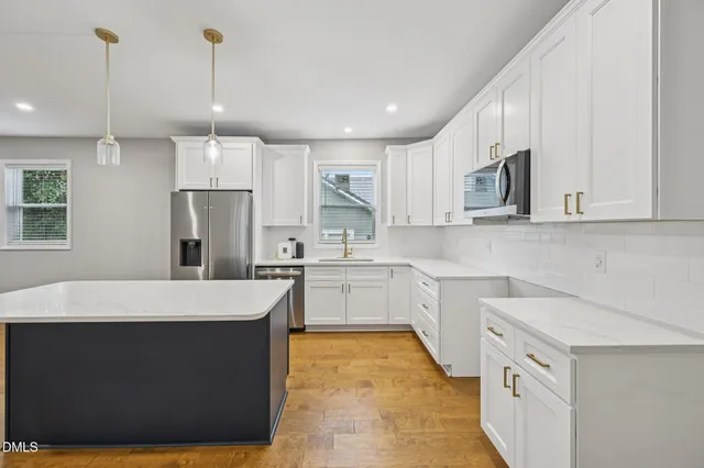 a kitchen with stainless steel appliances a refrigerator and a stove top oven