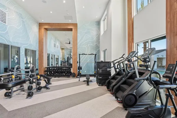 a living room with furniture gym equipment and a large window
