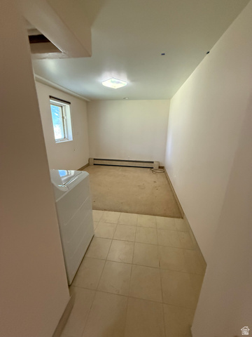 328 Heather Ridge Circle Sandy, UT 84070 - Photo 28 of 32 Utility area featuring square tile flooring, a window, and a baseboard heater