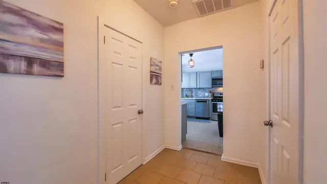 a view of a hallway with wooden floor and a bathroom