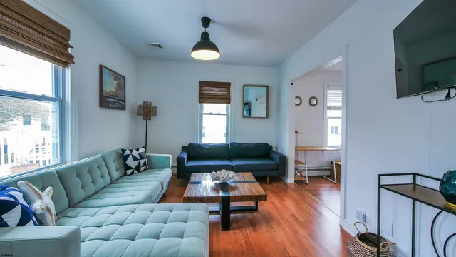 a living room with furniture and a wooden floor