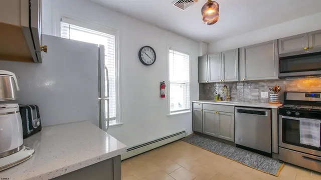 a kitchen with stainless steel appliances granite countertop a sink a stove a refrigerator a microwave oven with cabinets