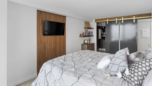 a bedroom with a bed and a flat screen tv