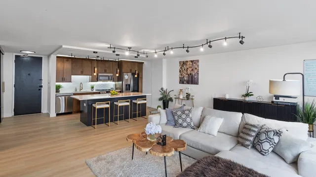 a living room with stainless steel appliances kitchen island granite countertop furniture and a kitchen view