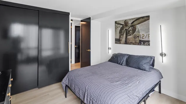 a bedroom with a bed and a painting on the wall